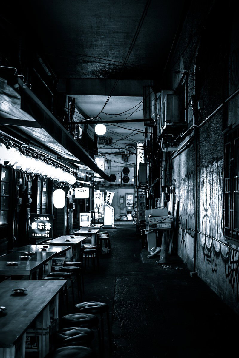 高架下の路地裏に並ぶ居酒屋の建ち並ぶ夜の風景
