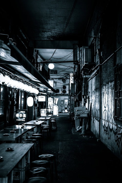高架下の居酒屋が建ち並ぶ路地裏の夜間風景の写真