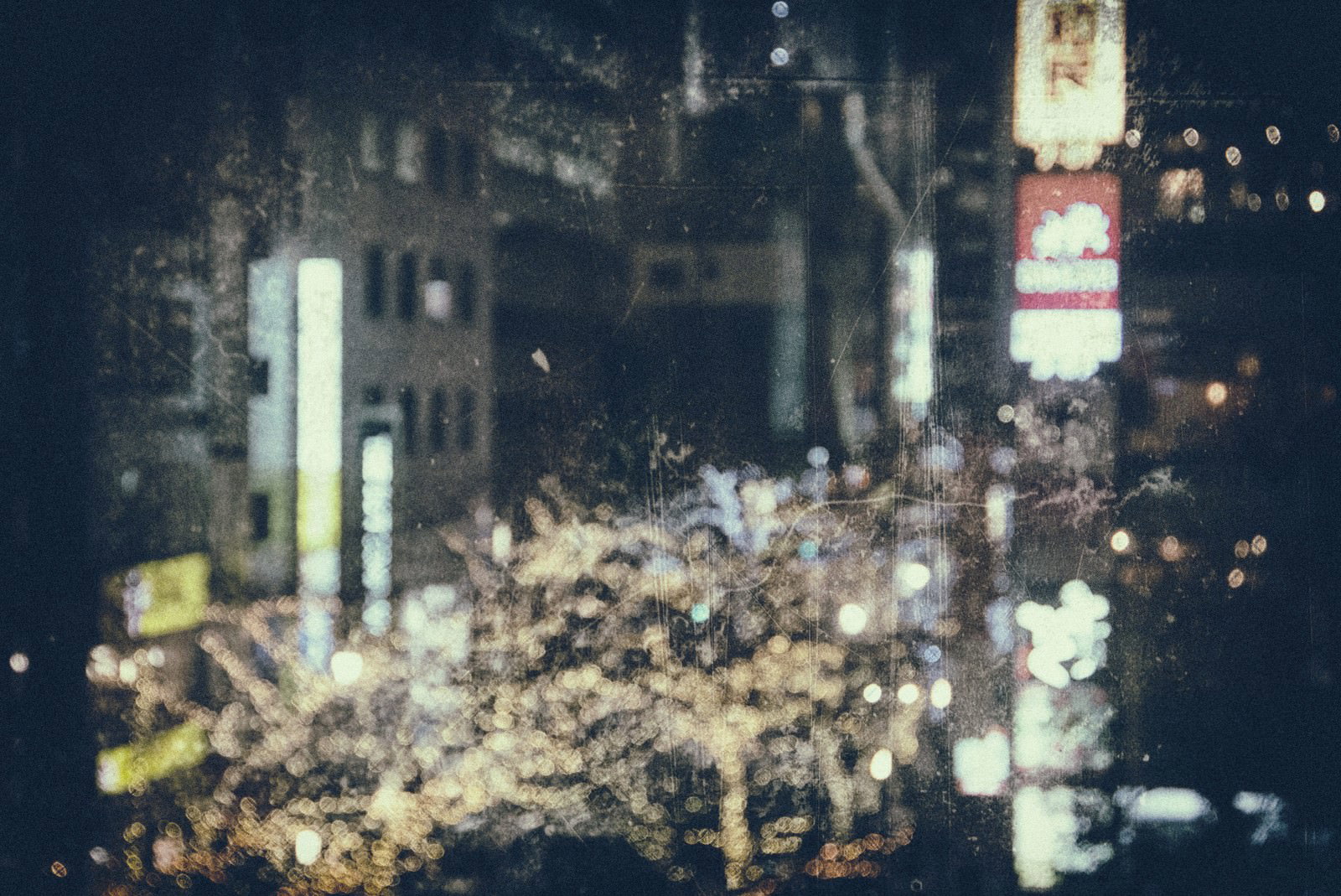 ネオンライトで照らされた都市の繁華街をフィルム風に撮影した夜景