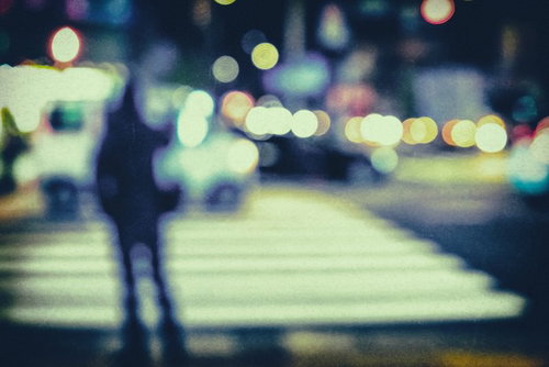 夜間の横断歩道で信号待ちする歩行者（ノイズ）