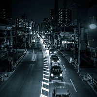 工事による片側一車線の夜間渋滞で連なる車列と街灯の写真