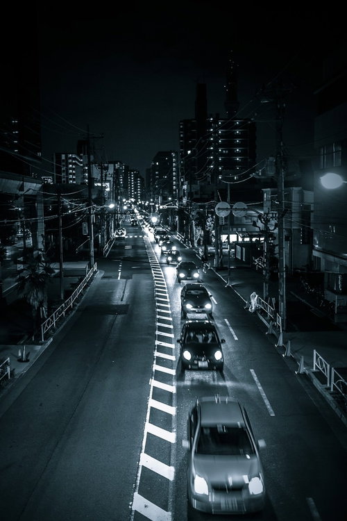 工事による片側一車線の夜間渋滞で連なる車列と街灯