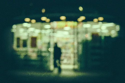 深夜のコンビニの外観をノイズ越しに捉えた一夜景