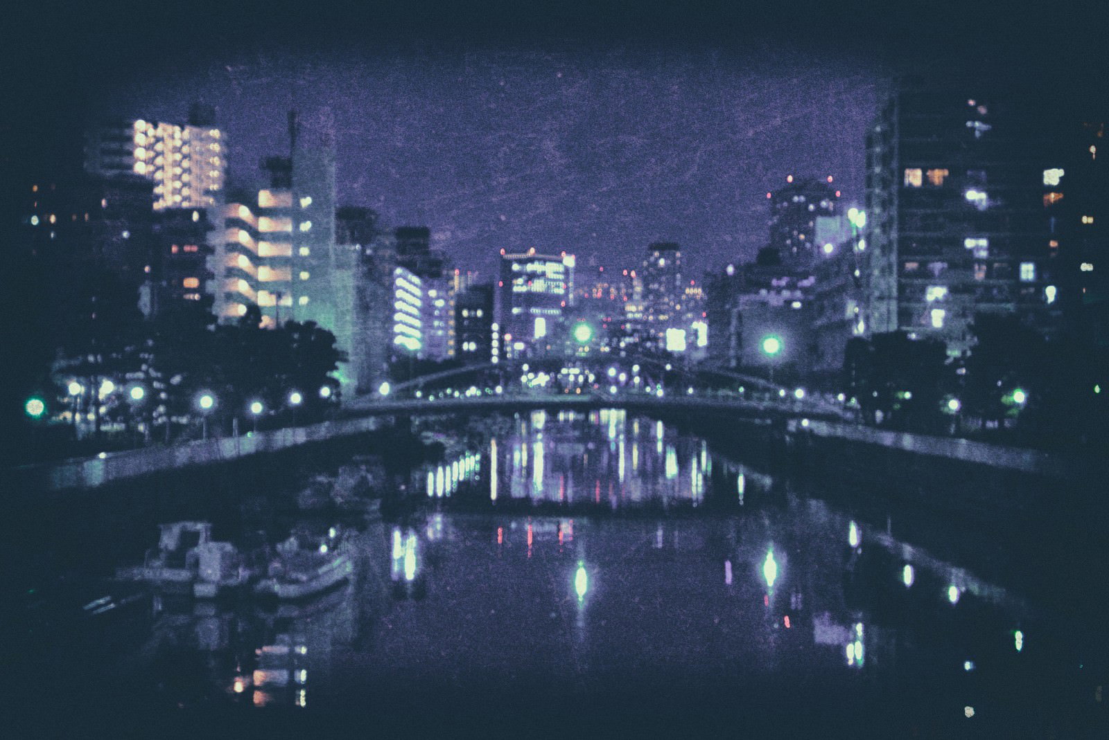 照明で輝く高層ビルと河川に映る光の夜景