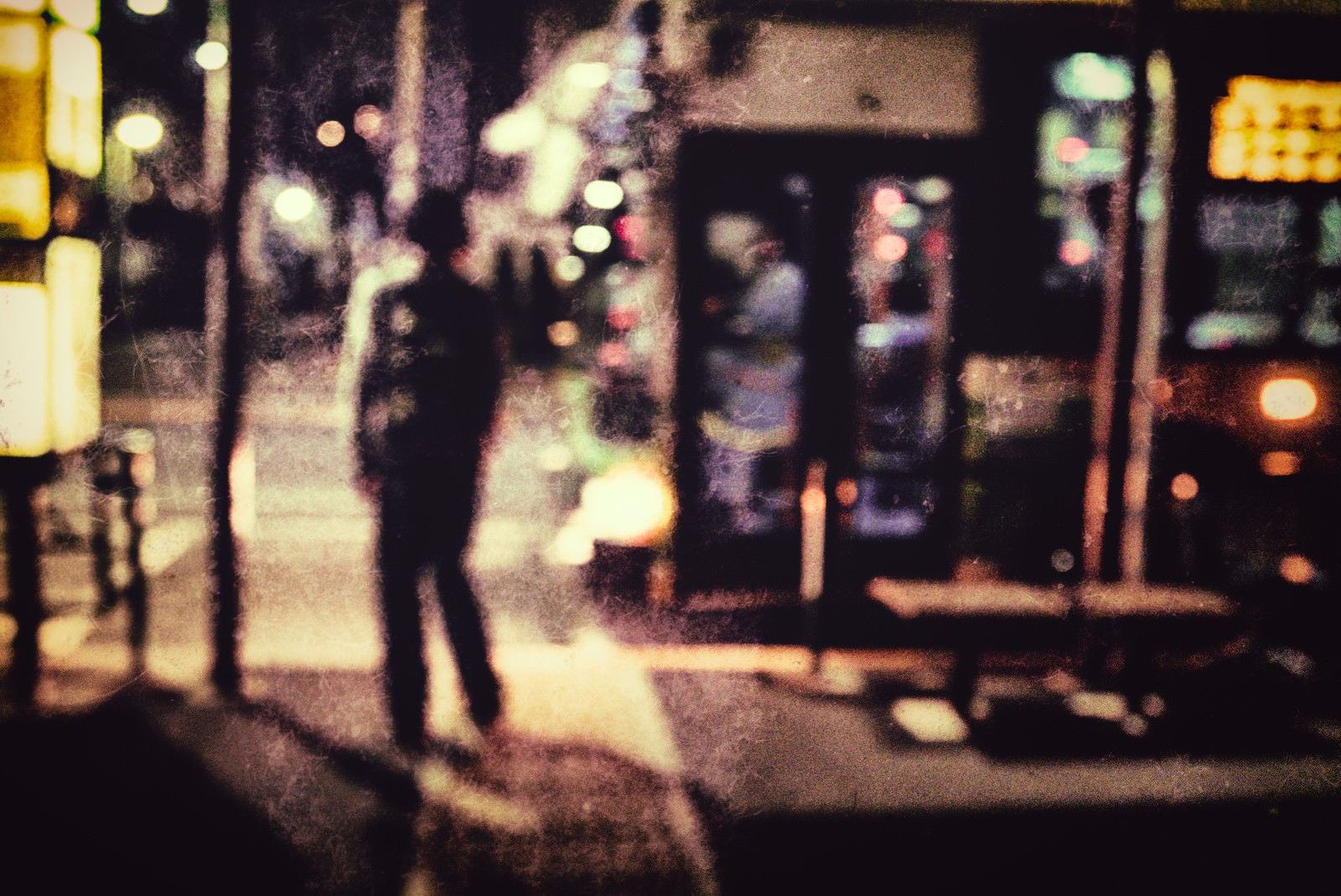 ノイズのかかった夜の繁華街に浮かぶぼやけた人影