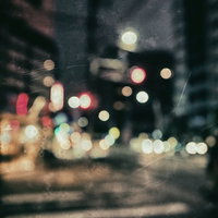 ピンボケの夜の街並み 深夜の光と雨に濡れた暗い路面の写真