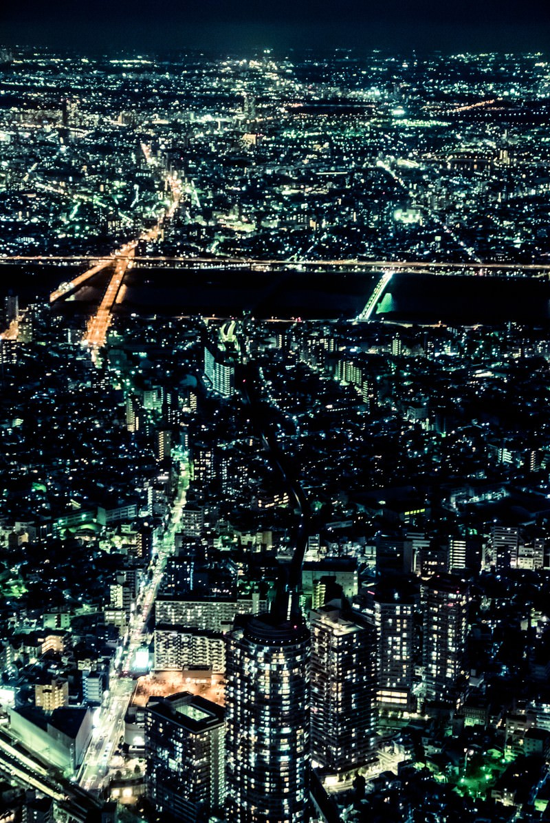高層ビルから見下ろす川と橋のある都会の夜景