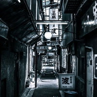 下町の路地裏の飲み屋街をゆく、懐かしい居酒屋と提灯の夜景の写真