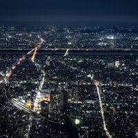 都会の夜景を照らす街路と橋 川沿いの高層ビル群の写真