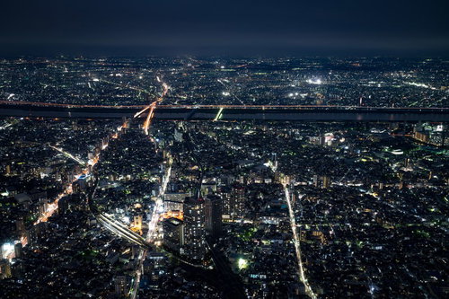 都会の夜景を照らす街路と橋 川沿いの高層ビル群
