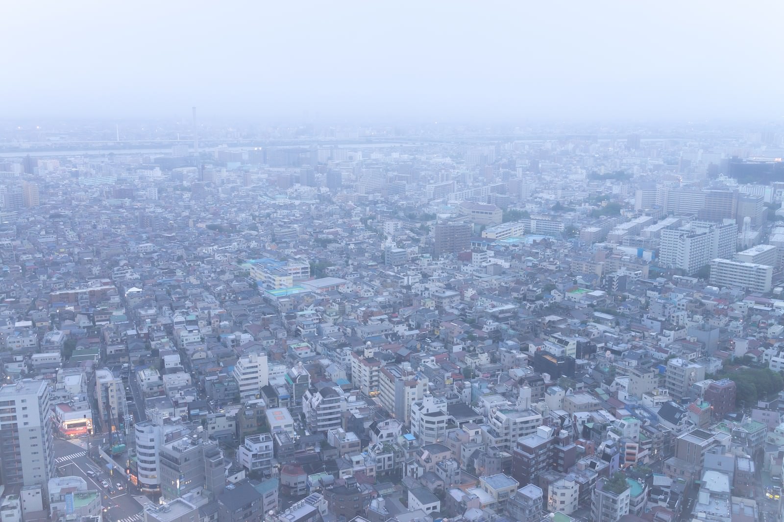 霧に覆われた都市の住宅街と建物が密集している空撮写真