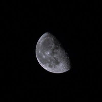夜空に浮かぶ2/3の純情な半月と星々の夜景の写真