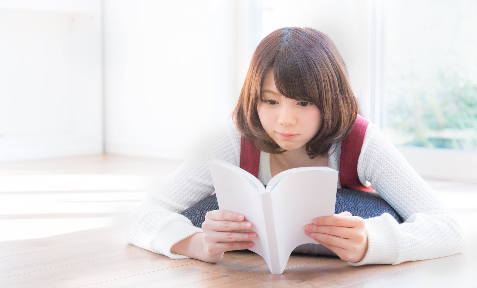 リビングの床で本を読む女性［モデル：みき。］