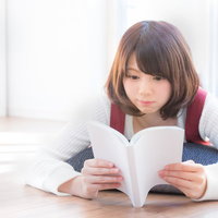 休日を読書で過ごす女性、リビングで本を読むの写真