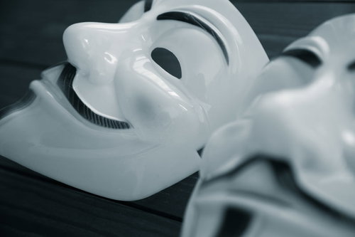 複数の仮面をかぶったハッカーの顔、匿名のサイバー犯罪者