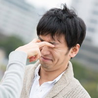 恋人との喧嘩で目を潰される男性の写真