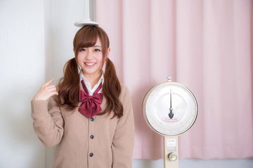身長伸びたかな、体重計の前で笑顔の女子高生