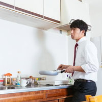 キッチンのシンクで虫を見つけ、どうやって退治しようか考える男性の写真