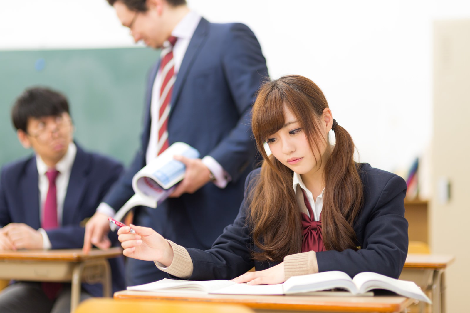 教室で教科書を広げて授業を受ける女子高生と男子高生［モデル：河村友歌 Max_Ezaki 大川竜弥］