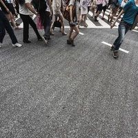 横断歩道を往来する人々の足元の写真