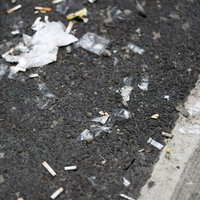 路地に散らばるタバコの吸殻とゴミの写真