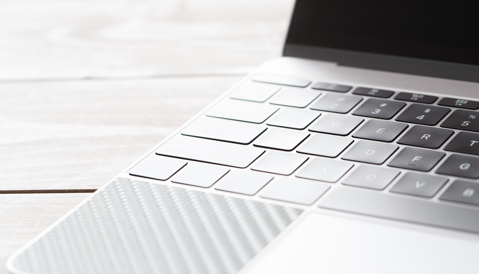 白いテーブルの上のMacBookキーボードのアップ