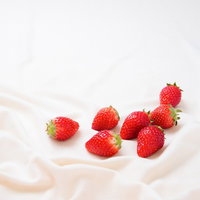 白い布の上に並んだ赤いいちごの写真