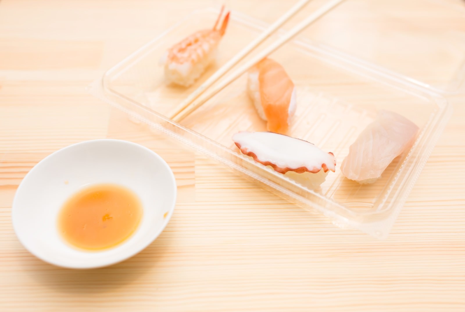 透明な皿にエビとタコとイカの握り寿司3個が箸と醤油の小皿と共に並んでいる