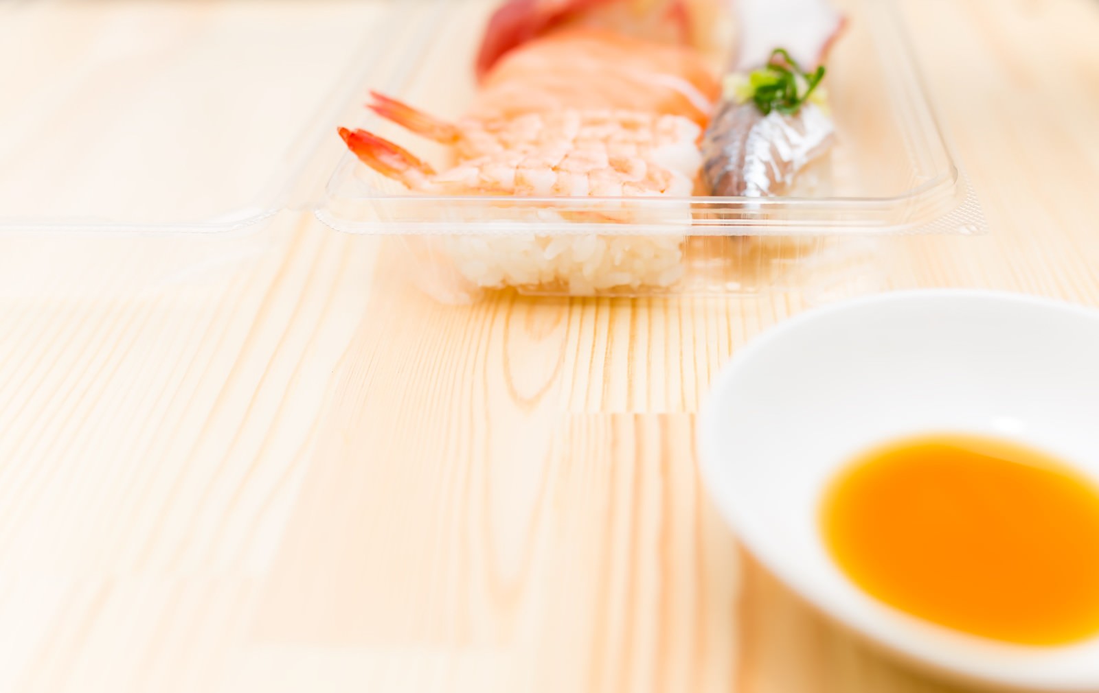 プラスチックパックに入った握り寿司と醤油皿