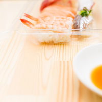 パックに入ったセール品の寿司と醤油の写真