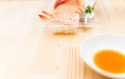 パックに入ったセール品の寿司と醤油