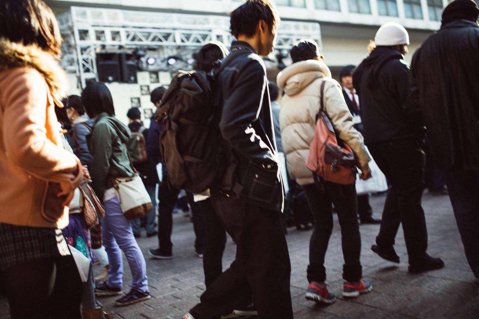 冬服を着た大勢の人が立ち並ぶ屋外の人混みの様子