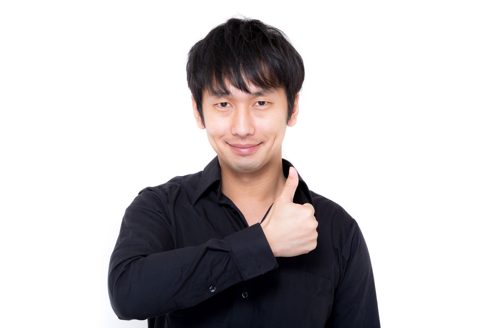 黒いシャツを着た男性が親指を立てていいねのジェスチャーをしており、笑顔を浮かべている［モデル：大川竜弥］