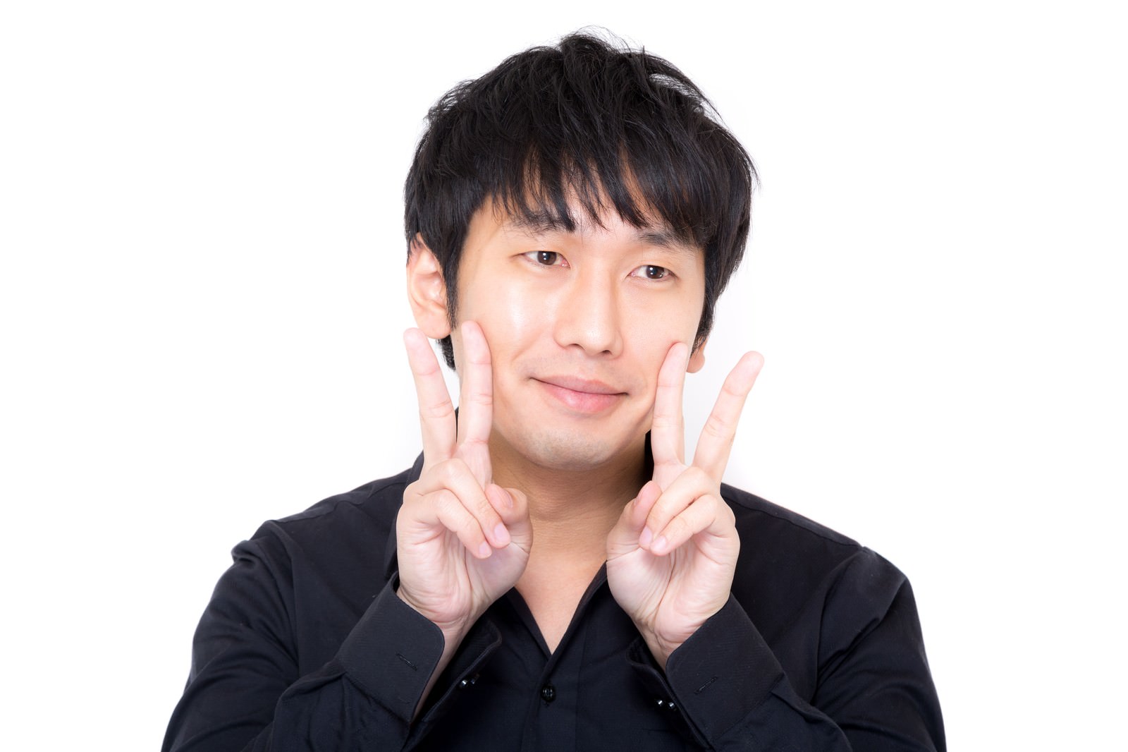 黒シャツの男性が両手でダブルピースをして照れた表情［モデル：大川竜弥］