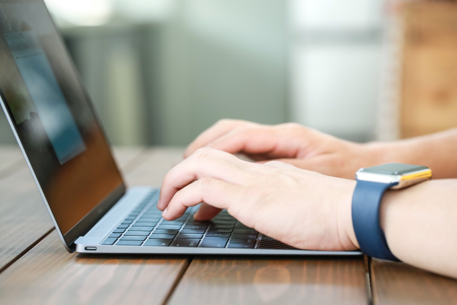 MacBookをタイピングするスマートウォッチ姿の手元