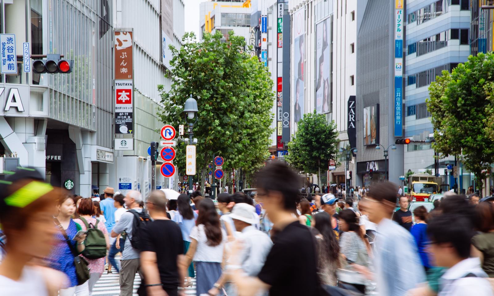 渋谷駅前のスクランブル交差点で大勢の人が横断歩道を渡っている