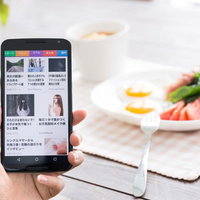 朝食時にスマートニュースでニュースをチェックする女性の写真