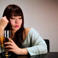 ワイングラスを持って赤くなる女性の写真