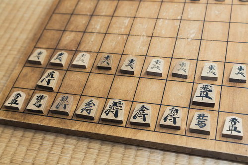 これから始まる将棋の対局、木製盤に初期配置された駒たち