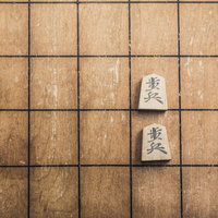 二歩！室内で対局中の将棋盤と駒の写真