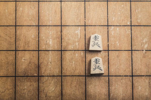 二歩！室内で対局中の将棋盤と駒の写真