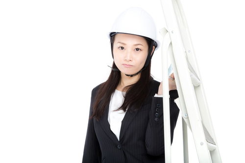 白いヘルメットを被ってスーツで脚立を運ぶ庶務課の女性