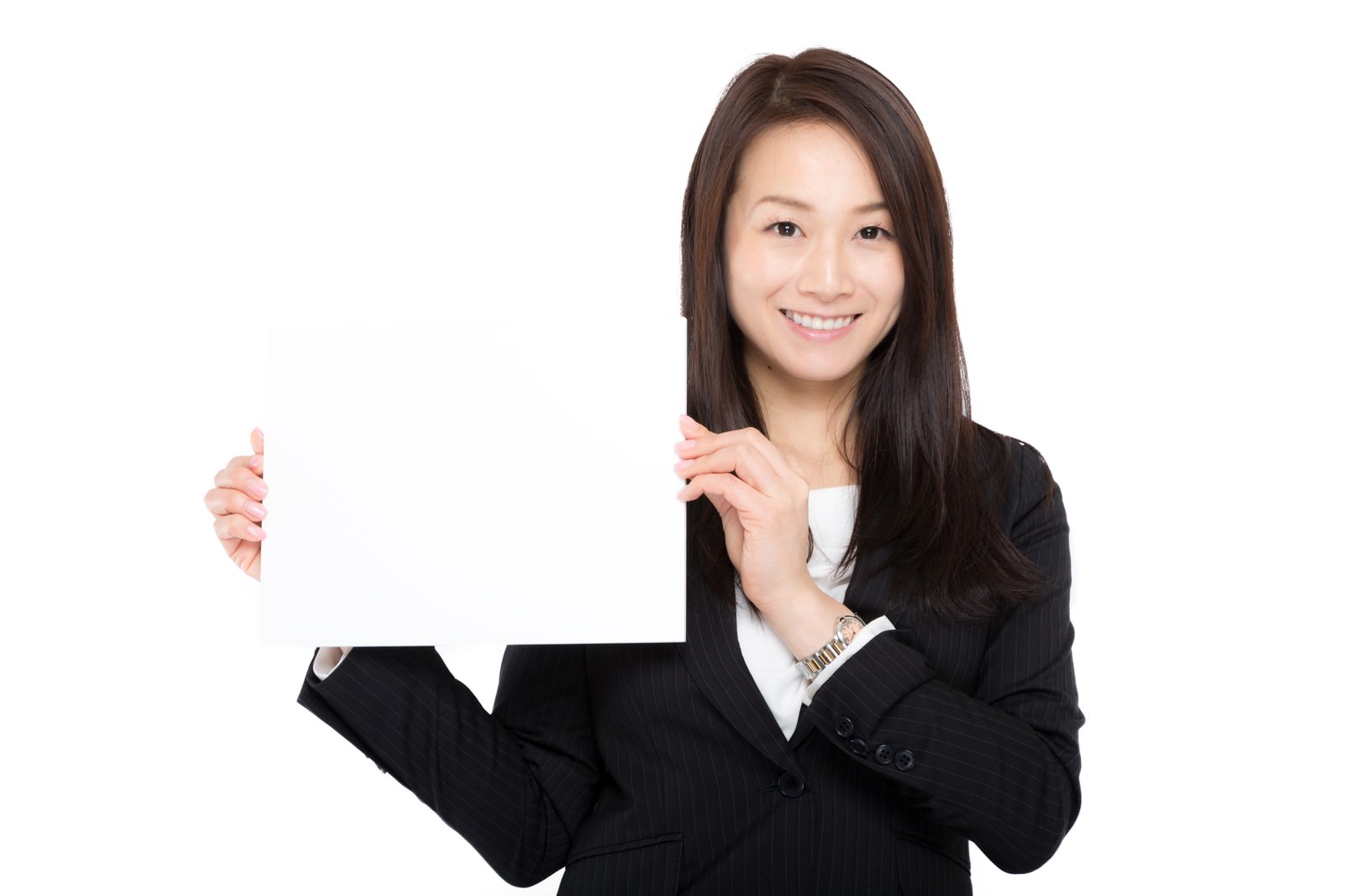 白いボードを掲げて笑顔で案内する黒いスーツ姿の女性［モデル：土本寛子］