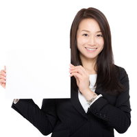 白いボードを掲げてお知らせする受付の女性の写真