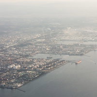 スモッグに覆われた工業地帯と港湾施設の航空風景の写真
