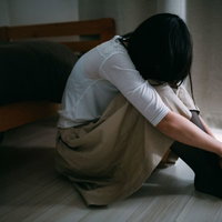 失恋のショックで床に座り込む女性、傷心の瞬間の写真