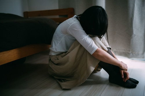 失恋のショックで床に座り込む女性、傷心の瞬間