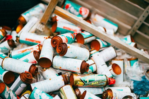 不法投棄されたスプレー缶とゴミ、さび付いた廃棄物の写真