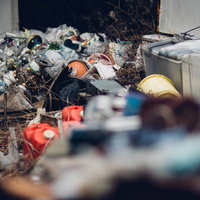 不法投棄されたゴミ屋敷の跡地に積み重なる家電と廃棄物の写真