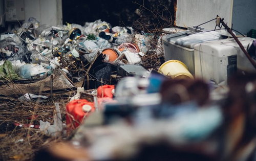 不法投棄されたゴミ屋敷の跡地に積み重なる家電と廃棄物の写真